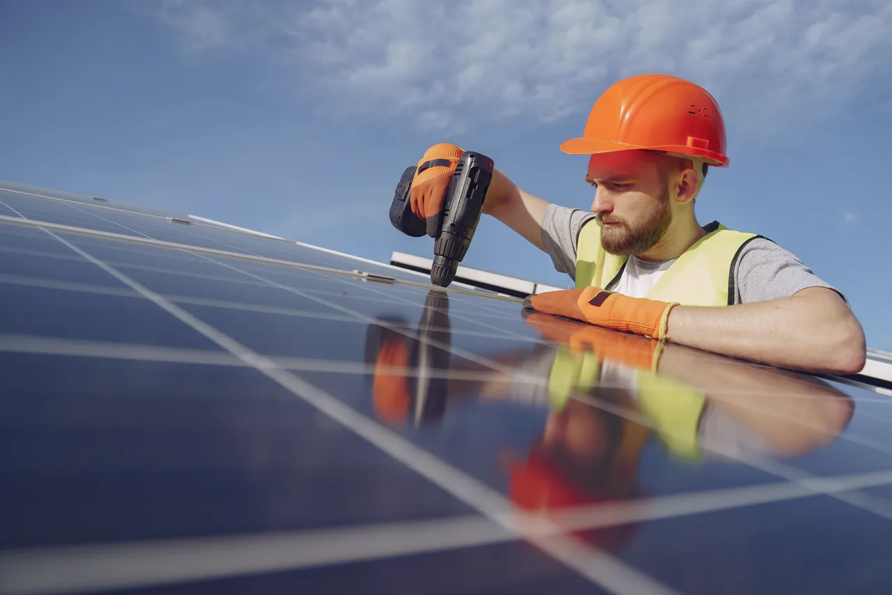 An installer fixing solar panels on a roof
